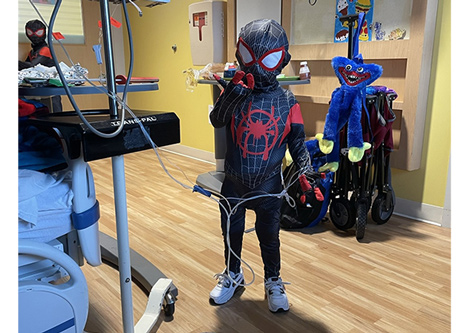 Lukas Ramos is posing in his Spider-man costume at CHRISTUS Children's